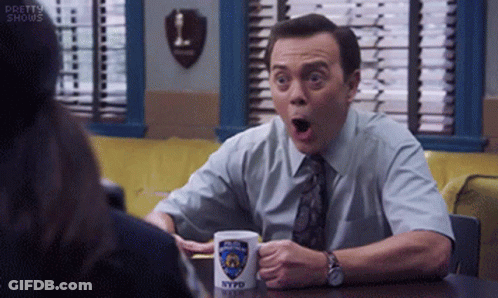 Man Sitting At Table With NYPD Mug GIF