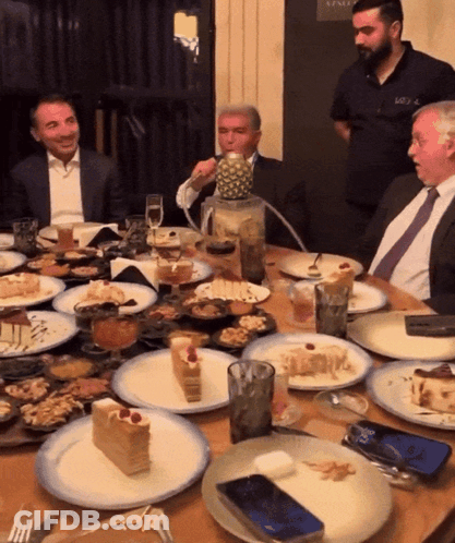 Man Sitting At Table With Pineapple GIF