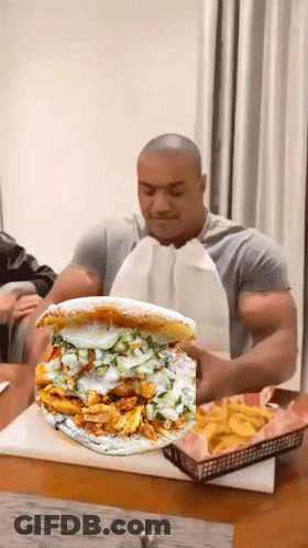 Man Sitting At Table With Sandwich And French Fries GIF