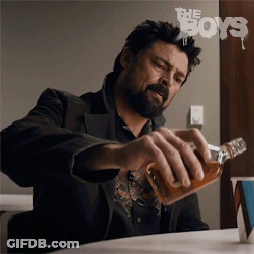 Man Sitting At Table With Whiskey Bottle In Front Of The Boys Sign GIF