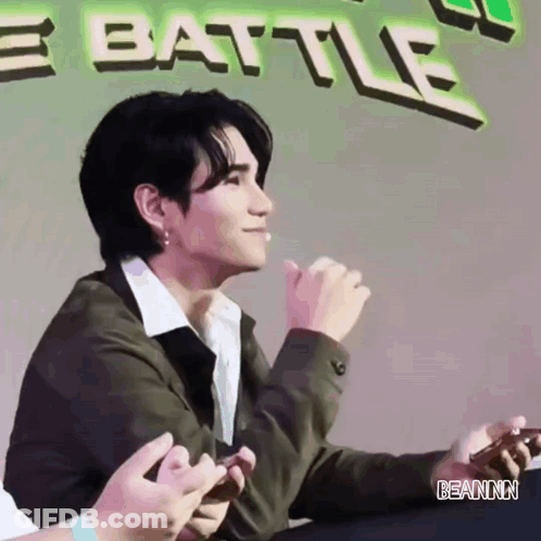 Man Sitting By Banner Saying Battle GIF