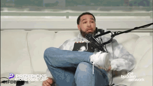 Man Sitting Crossed Legs In Front Of Microphone GIF