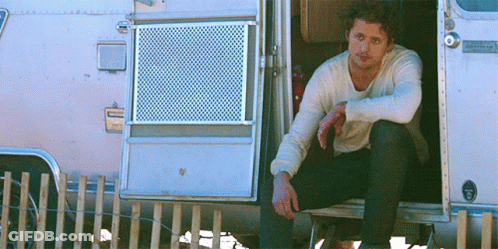 Man Sitting In Airstream Camper Doorway GIF