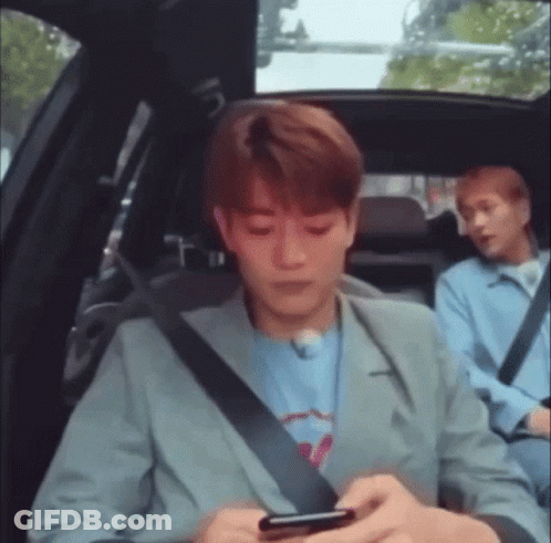 Man Sitting In Back Seat Looking At Phone GIF