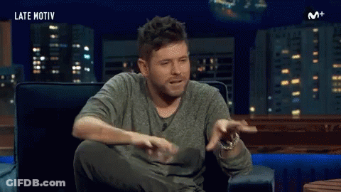 Man Sitting In Chair Arms Outstretched Mouth Open GIF