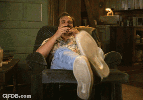 Man Sitting In Chair Feet Up Eating Hamburger GIF