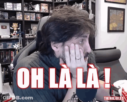 Man Sitting In Chair Hands On Face Saying Oh La La GIF