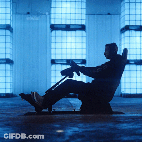 Man Sitting In Chair Holding Steering Wheel GIF