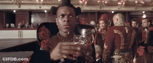 Man Sitting In Chair Holding Wine In Front Of Crowd GIF