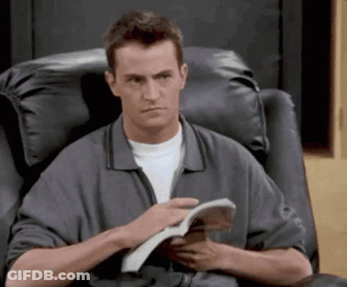 Man Sitting In Chair Reading Magazine GIF