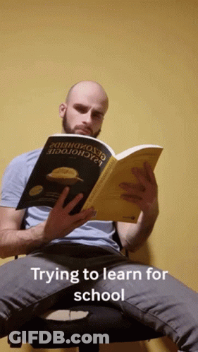 Man Sitting In Chair Reading Trying To Learn For School GIF