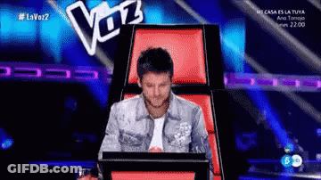 Man Sitting In Chair With Voz Sign GIF