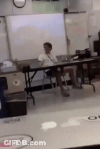 Man Sitting In Classroom With Legs Crossed GIF