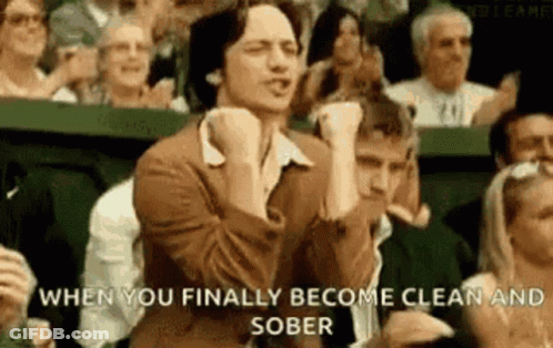 Man Sitting In Crowd With Fist In Air GIF