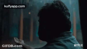 Man Sitting In Dark Room Looking Out Window GIF