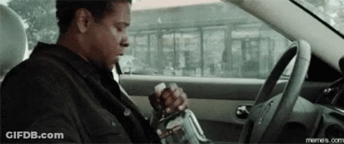 Man Sitting In Driver Seat Holding Bottle GIF