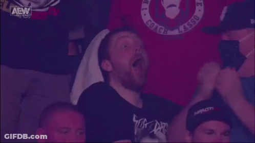 Man Sitting In Front Of AEW Sign GIF