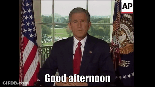 Man Sitting In Front Of American Flag Saying Good Afternoon GIF