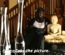 Man Sitting In Front Of Buddha Statue Take The Picture GIF
