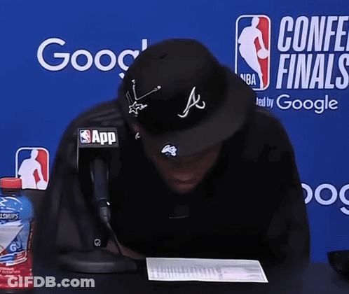 Man Sitting In Front Of Conference Finals Banner GIF