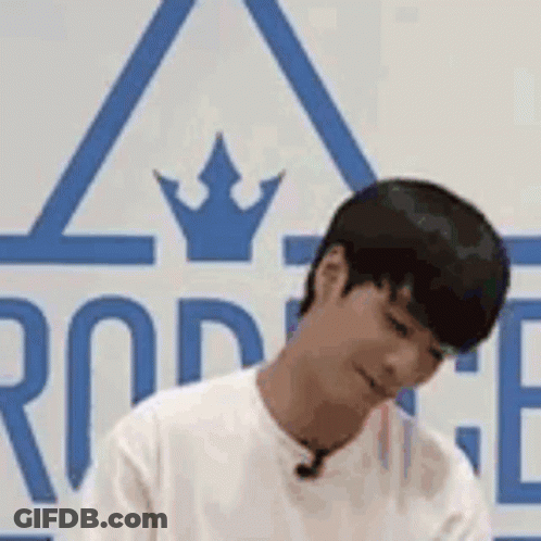 Man Sitting In Front Of Crowned Sign Looking Down GIF