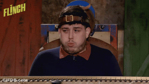 Man Sitting In Front Of Flinch Sign GIF