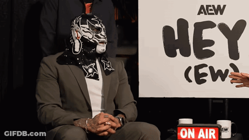 Man Sitting In Front Of Hey Crew Sign GIF