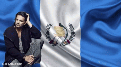 Man Sitting In Front Of Libertad Flag GIF