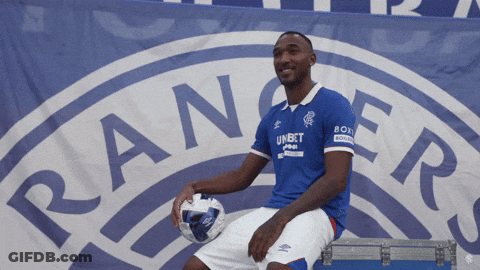 Man Sitting In Front Of Rangers Logo Holding Soccer Ball GIF