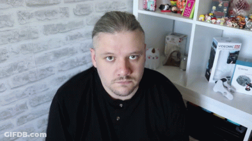 Man Sitting In Front Of Shelf With Videomic Box GIF
