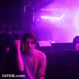 Man Sitting In Front Of Stage With Purple Lights GIF