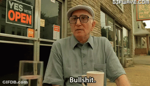 Man Sitting In Front Of Store Saying Yes We Are Open GIF