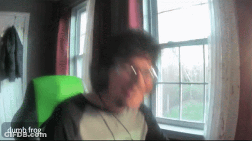 Man Sitting In Front Of Window With Dumb Frog Written On Screen GIF