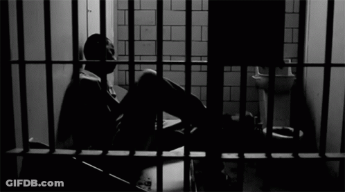 Man Sitting In Jail Cell GIF