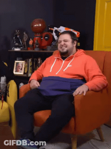 Man Sitting In Orange Chair With Picture Behind GIF