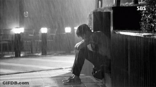 Man Sitting In Rain With Head Down GIF
