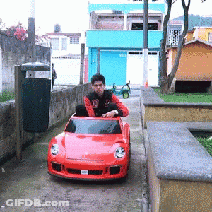 Man Sitting In Red Toy Car With D GIF