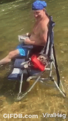 Man Sitting In Water With Dog On Lap GIF