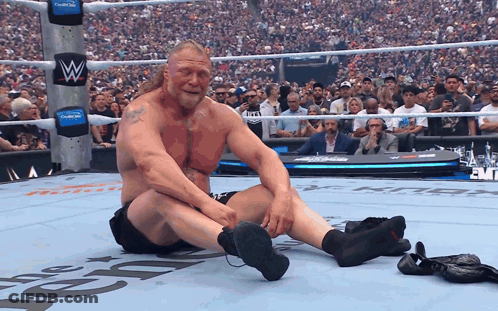 Man Sitting In Wrestling Ring With Letter W GIF