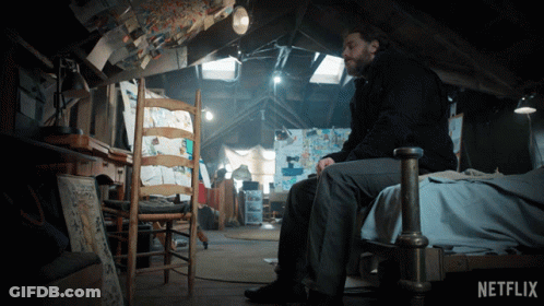 Man Sitting On Bed In Attic With Netflix Logo GIF