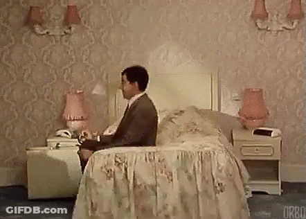 Man Sitting On Bed In Hotel Room Talking On Cell Phone GIF