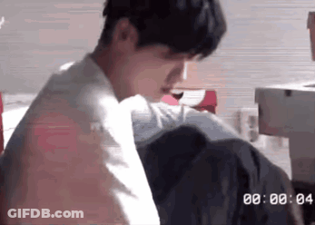 Man Sitting On Bed With Clock Saying 00:00 GIF