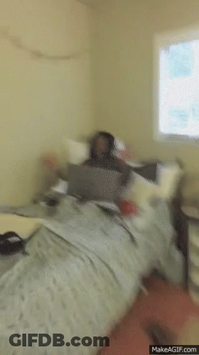 Man Sitting On Bed With Laptop Screaming GIF