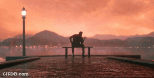 Man Sitting On Bench By Water GIF