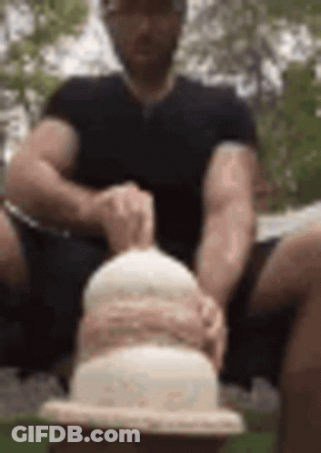 Man Sitting On Bench Holding Cake GIF
