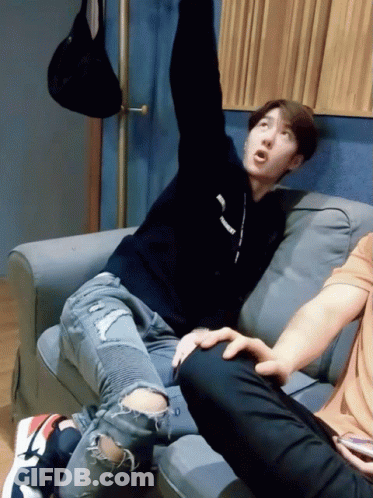 Man Sitting On Couch Arms Up Supreme Sweater GIF