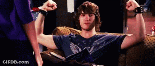 Man Sitting On Couch Flexing Muscles GIF