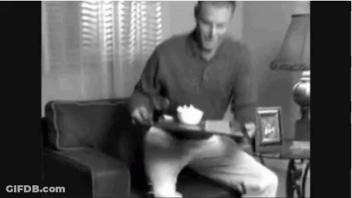Man Sitting On Couch Holding Food Tray GIF