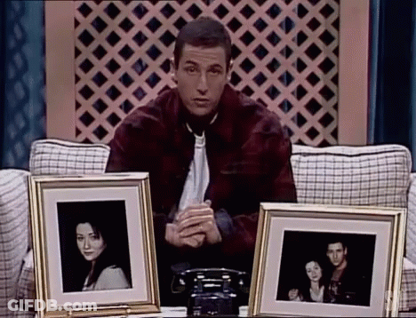 Man Sitting On Couch Holding Framed Photos GIF