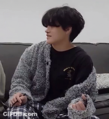 Man Sitting On Couch In Black Shirt And Gray Sweater GIF